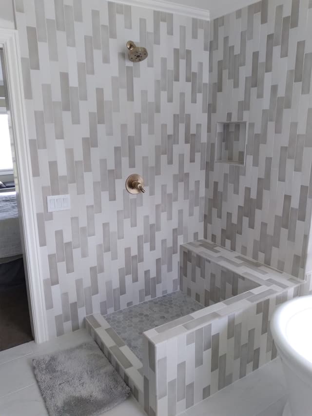 Modern bathroom shower with geometric tile and built-in bench