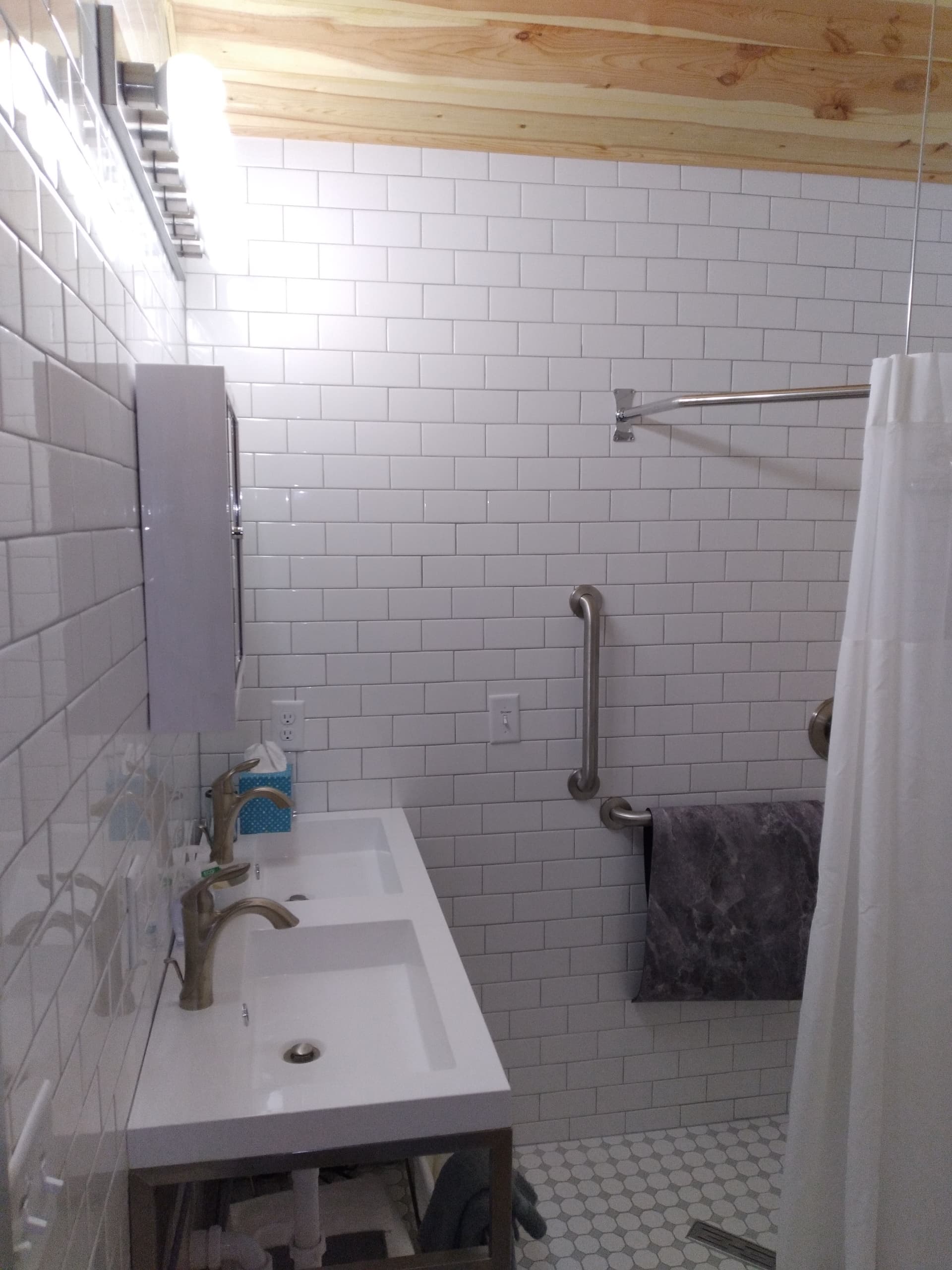 Modern bathroom with white subway tiles, double sink, and shower area