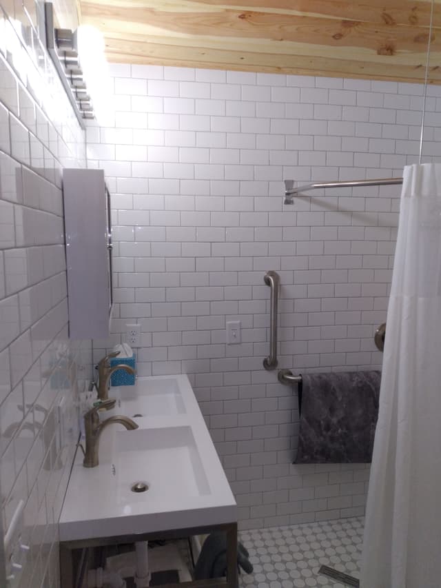 Modern bathroom with white subway tiles, double sink, and shower area