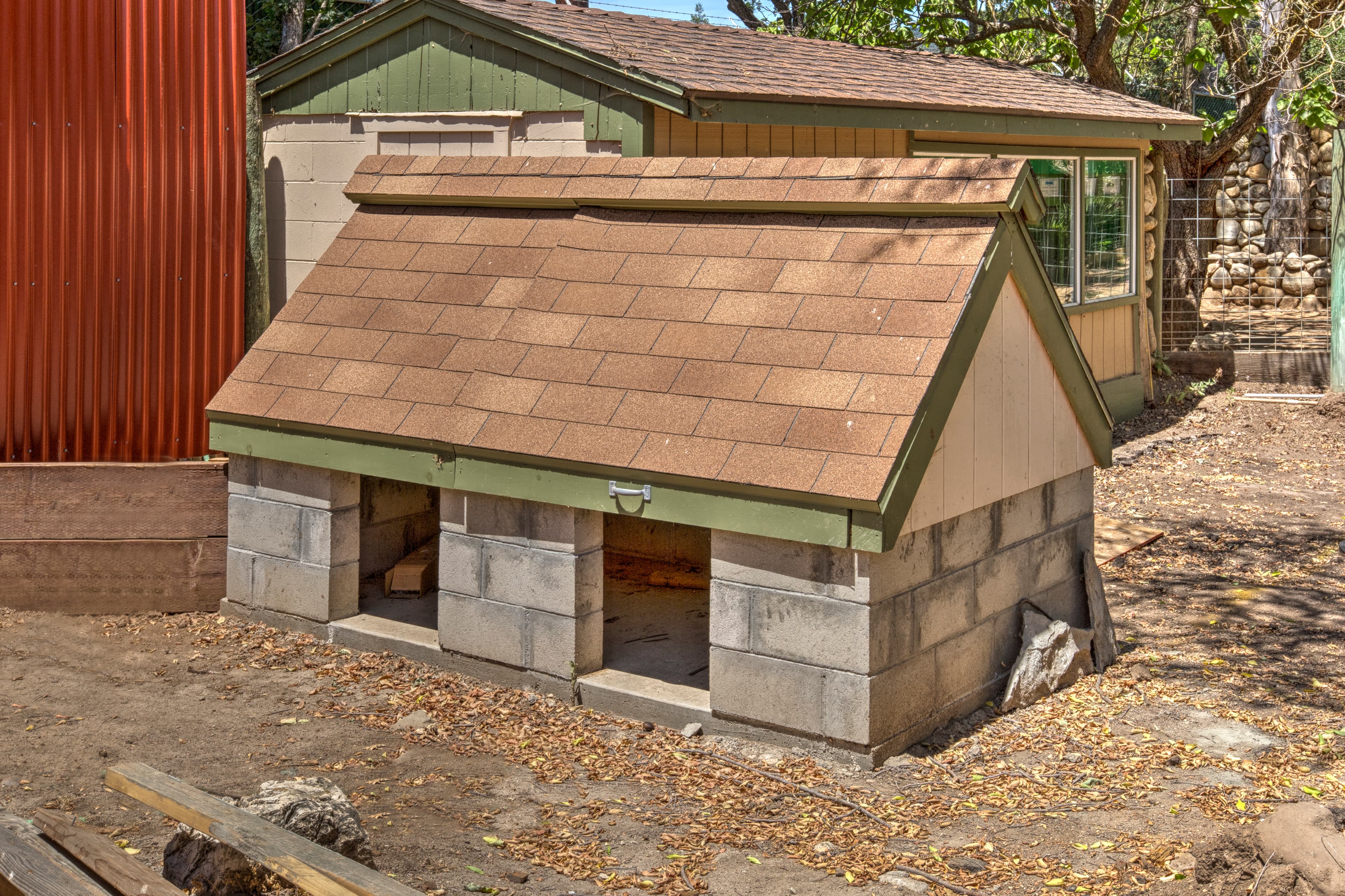 Outdoor dog house built with concrete blocks and a shingled roof
