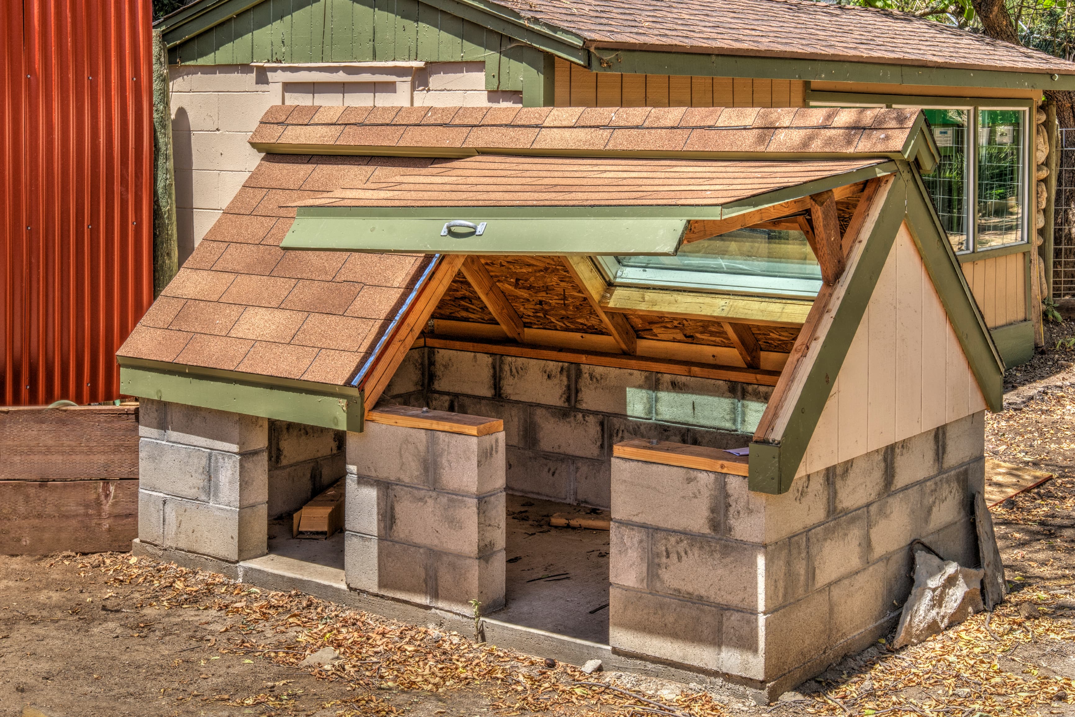Partially built small animal shelter with cinder block base and wooden roof
